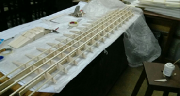 Wing rib and spar skeleton on the bench during hand assembly